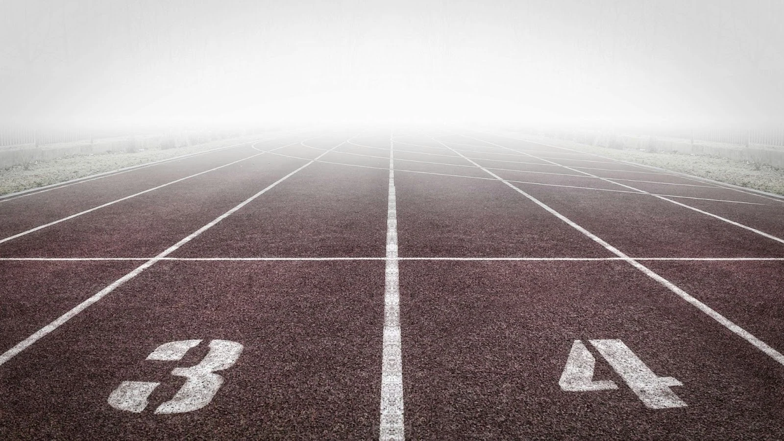 starting grid on a running track with fogs at the horizon in a first person point of view