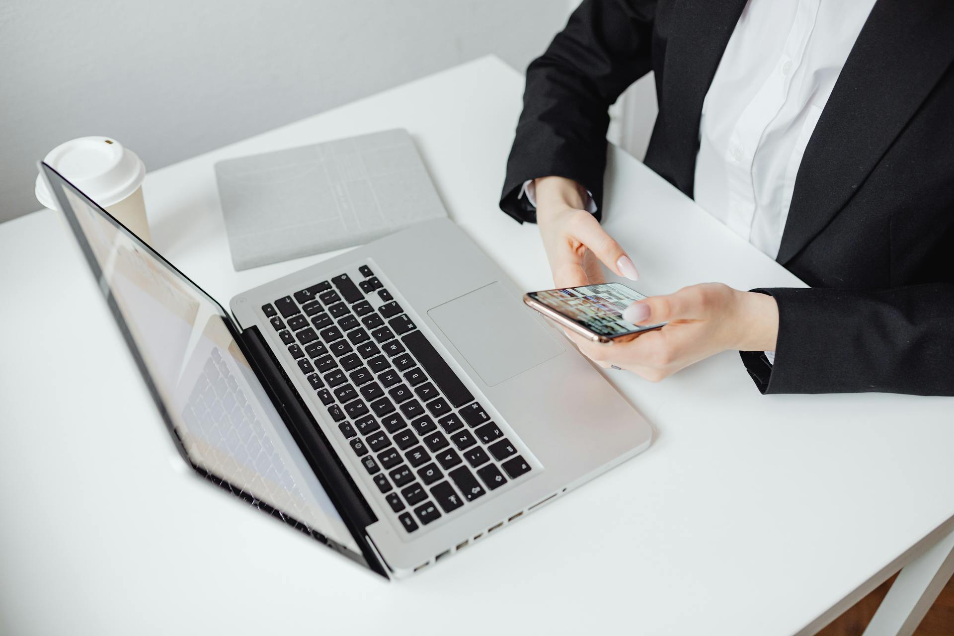 an eagle shot of an employee researching about Moonman Events online through a laptop and a mobile phone